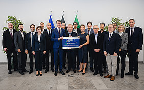 Gruppenfoto Klinikvertreterinnen und -vertreter mit Ministerpräsident Hendrik Wüst und Wissenschaftsministerin Ina Brandes.